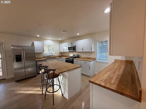 a kitchen with stainless steel appliances granite countertop a refrigerator and a stove top oven
