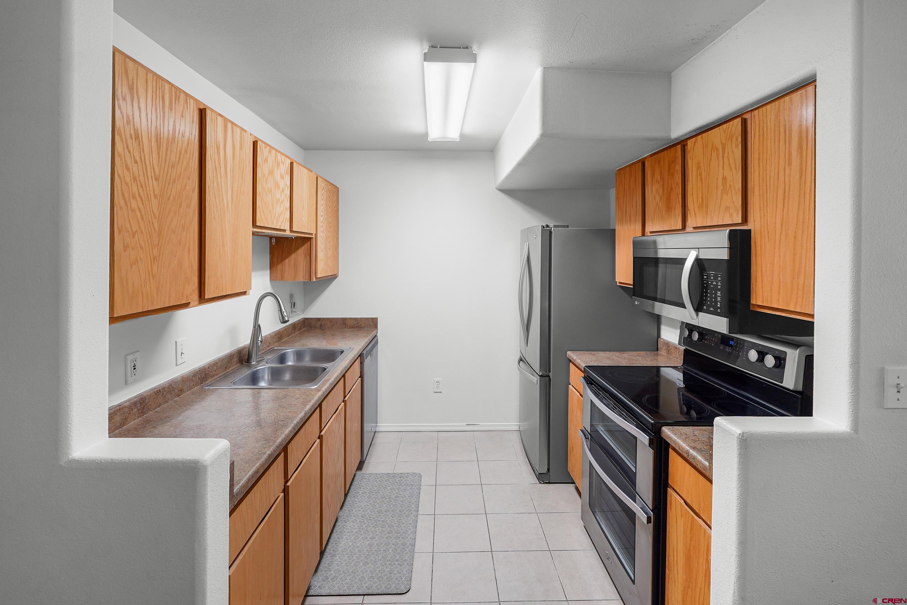 1100 Goeglein Gulch Road, Unit 163 Durango, CO 81301 - Photo 12 of 23 a kitchen with stainless steel appliances a stove sink and microwave
