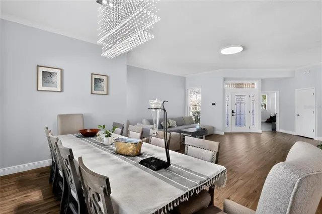 a living room with furniture a wooden floor and chandelier