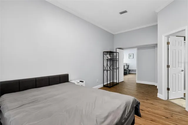 a bedroom with a bed and wooden floor