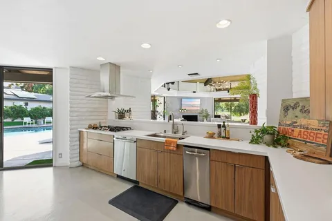 a dining room with furniture a floor to ceiling window and wooden floor
