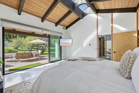 a bed sitting in a bedroom next to a large window