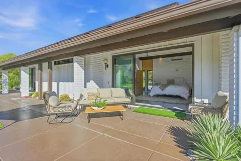 a spacious bedroom with a bed and glass door