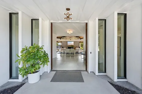 a view of a hallway with dining room and furniture