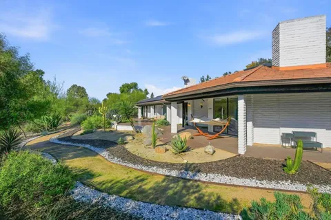 an aerial view of residential houses with outdoor space and trees