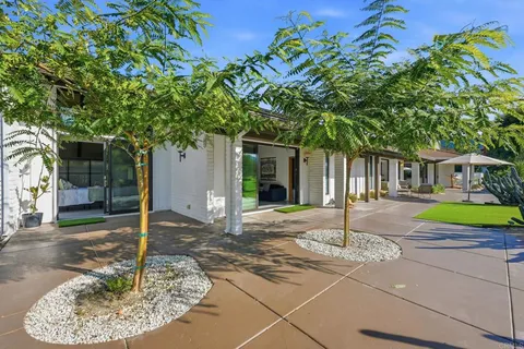 an aerial view of a house with a garden and trees