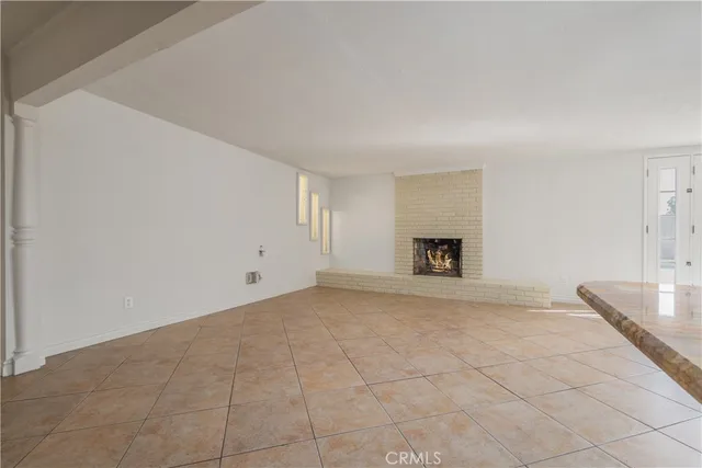 a view of an empty room with a fireplace and a window