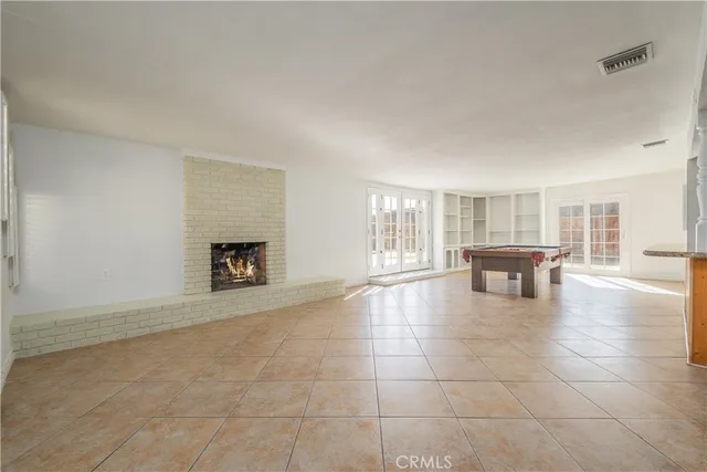 a living room with a table and a dishwasher next to a window
