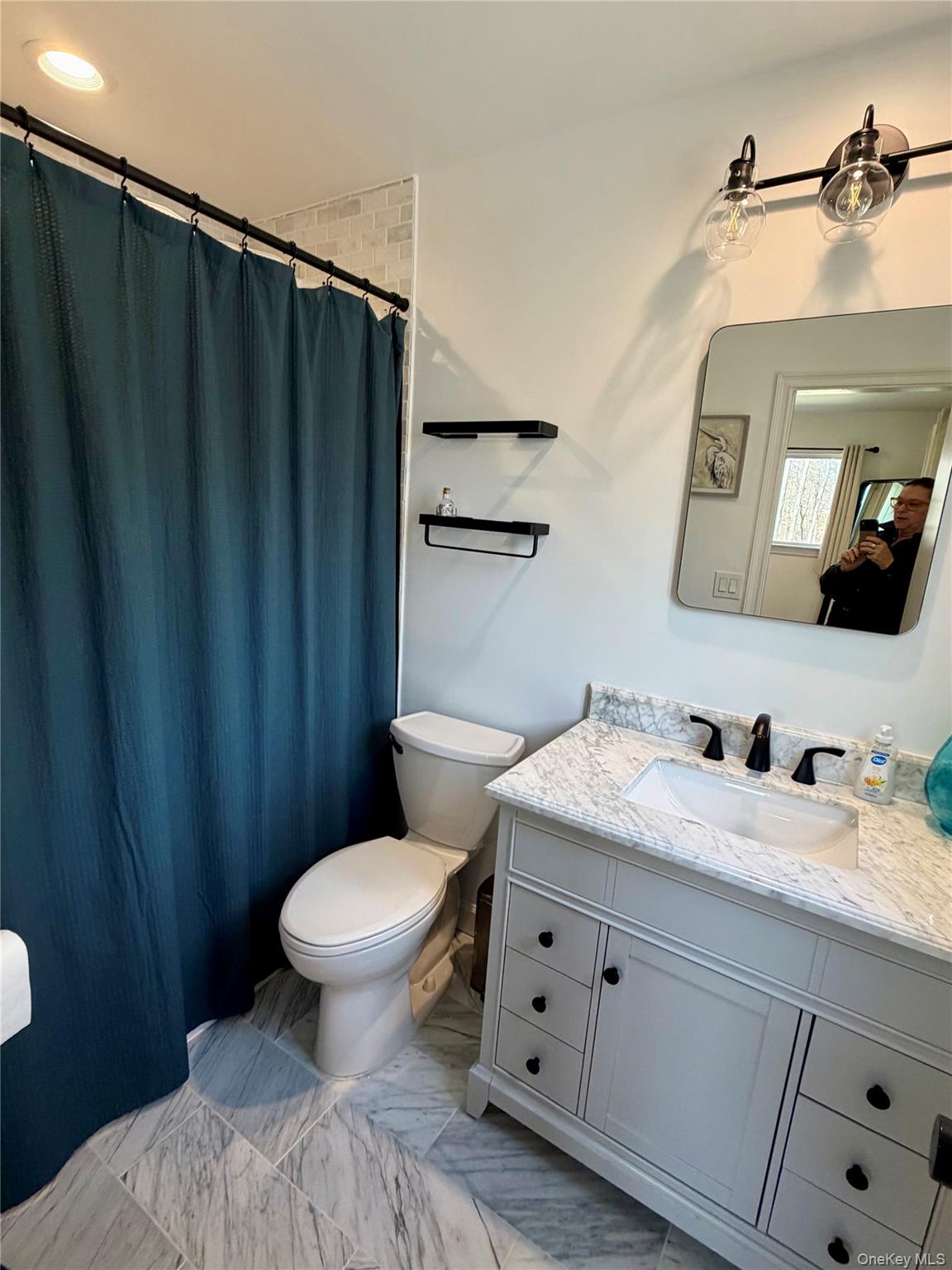 43 B Old Squires Road Hampton Bays, NY 11946 - Photo 6 of 12 a bathroom with a toilet sink and mirror