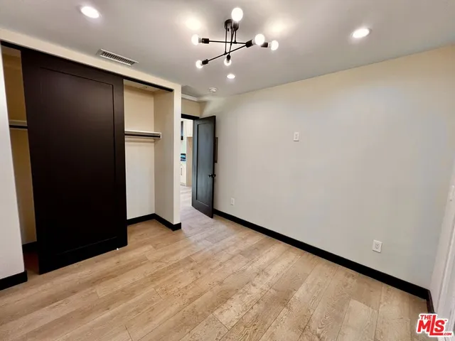 an empty room with closet and a ceiling fan