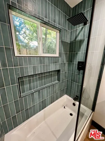 a bathroom with a sink a toilet a window and shower