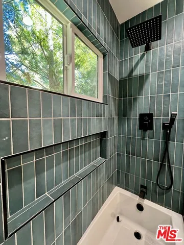 a bathroom with a bathtub and next to window