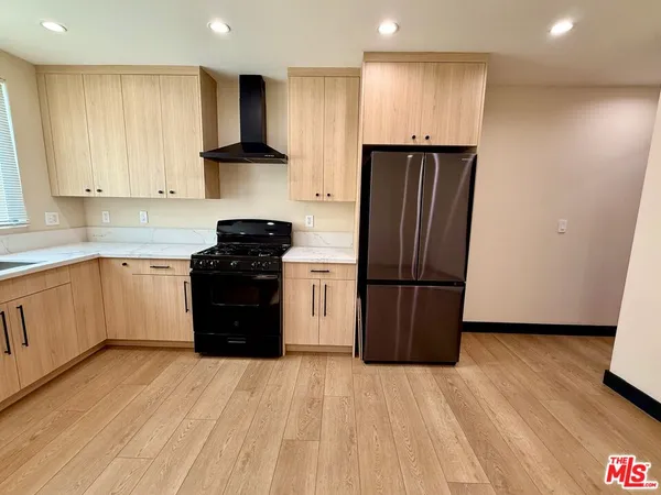 a kitchen with a refrigerator and a stove top oven