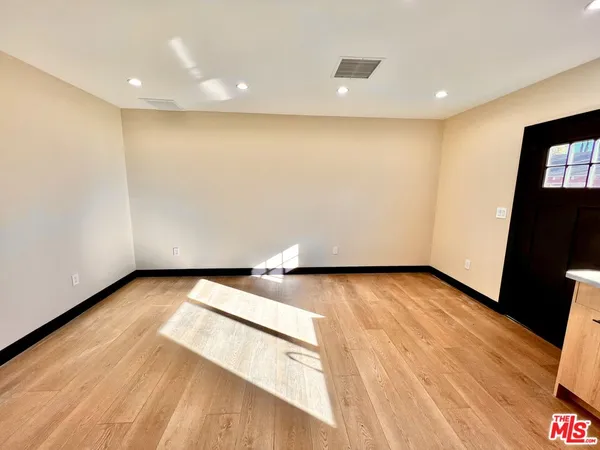 a view of an empty room with wooden floor