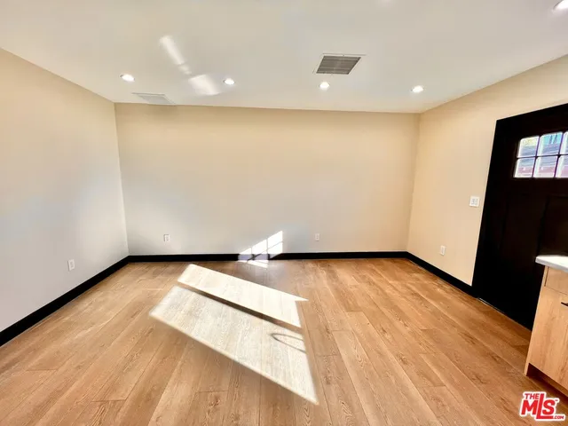 a view of an empty room with wooden floor