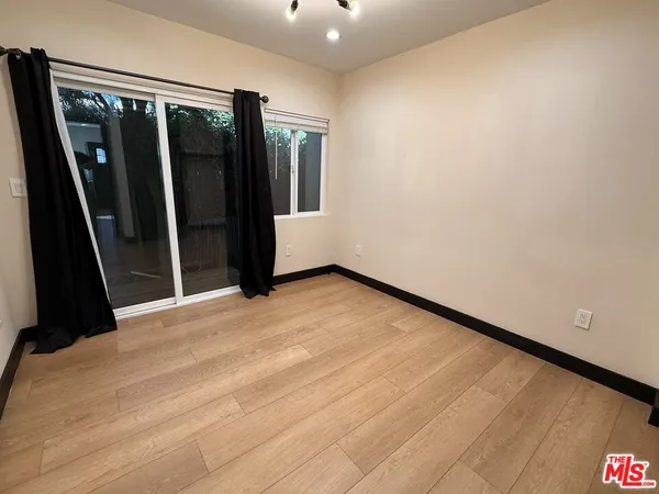 a view of a room with wooden floor and sliding door