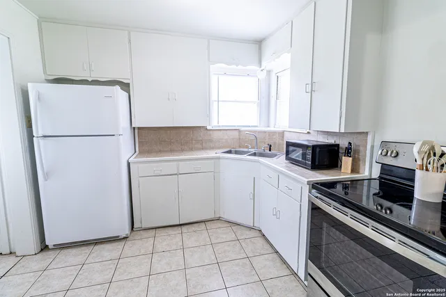 a kitchen with a sink a stove and a refrigerator