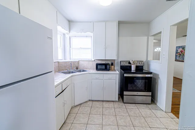 a kitchen with a sink cabinets and appliances