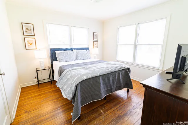 a bedroom with a bed window and a flat screen tv