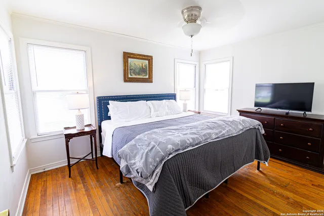 a bedroom with a bed and a flat tv screen on dresser