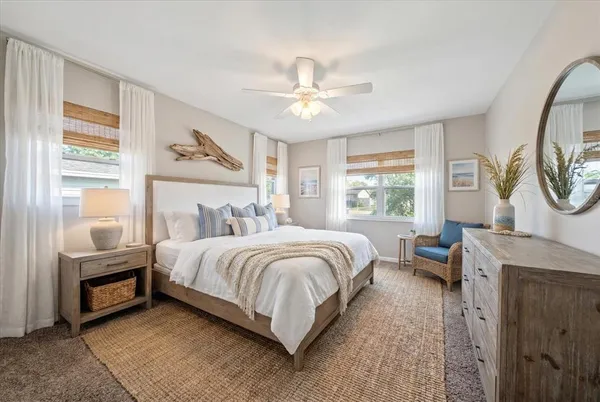 a bedroom with a bed a mirror and a large window