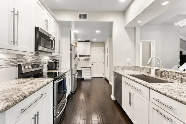 a kitchen with stainless steel appliances granite countertop a sink stove oven and refrigerator