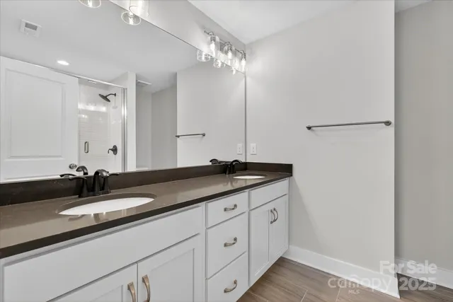a bathroom with double sink and a mirror
