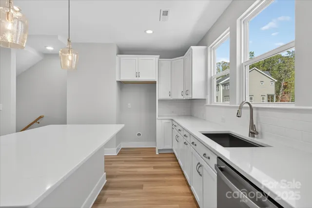 a kitchen with kitchen island a stove a sink a center island and windows