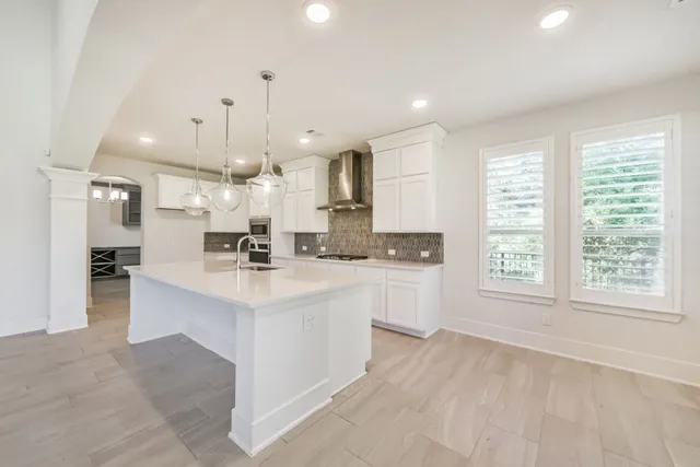a large white kitchen with a large window