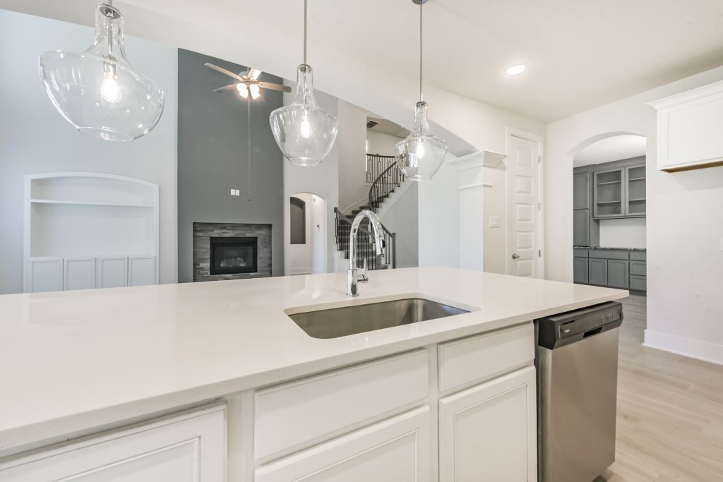 126 Keechie Creek Court Conroe, TX 77304 - Photo 25 of 50 a kitchen with a sink a refrigerator and a fireplace