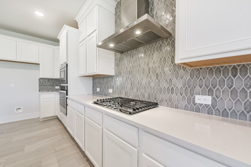 126 Keechie Creek Court Conroe, TX 77304 - Photo 26 of 50 a kitchen with stainless steel appliances granite countertop a sink a stove and a refrigerator