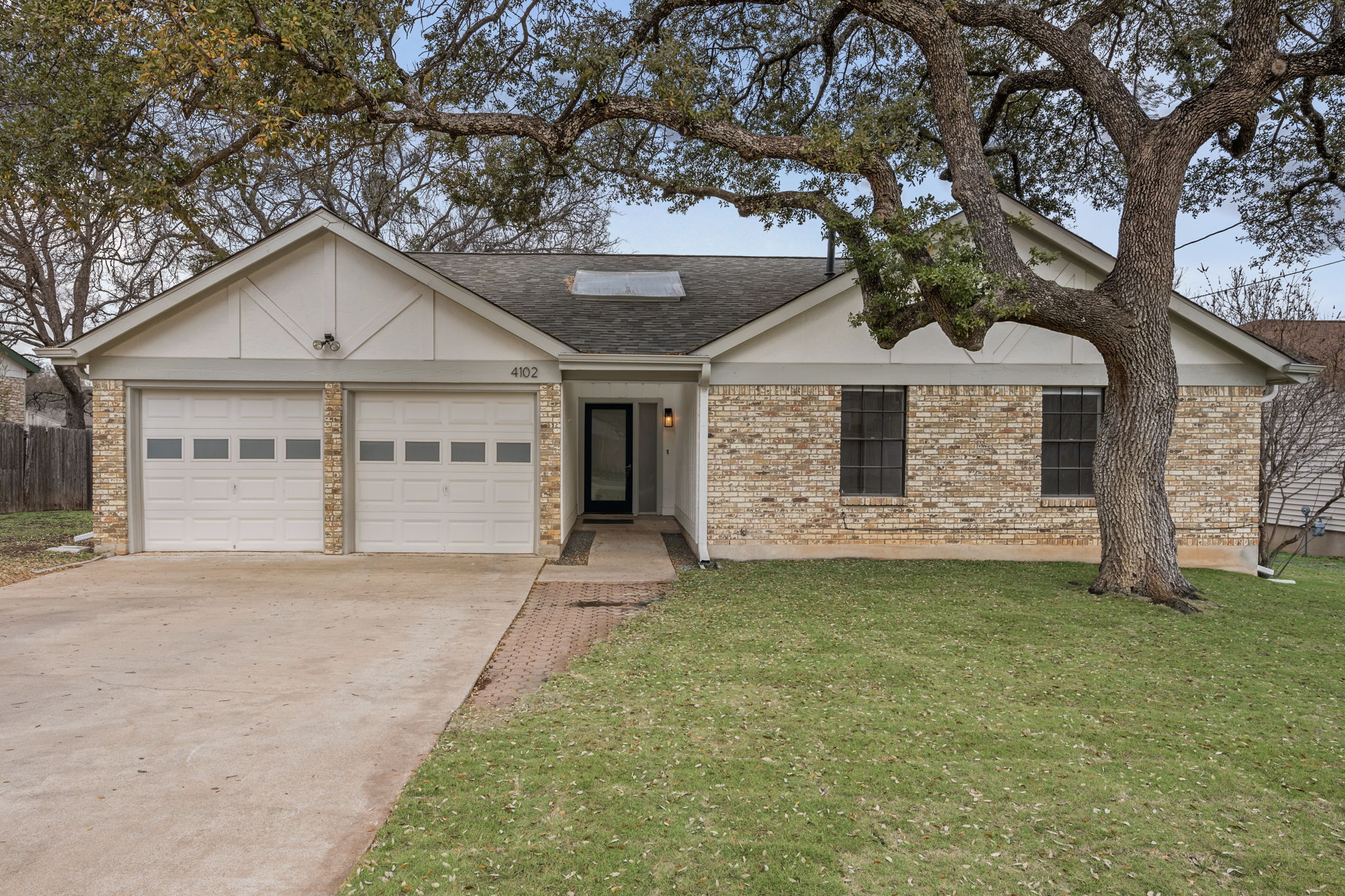 4102 Tamarack Trail Austin, TX 78727 - Photo 1 of 1 a front view of a house with a garden and yard