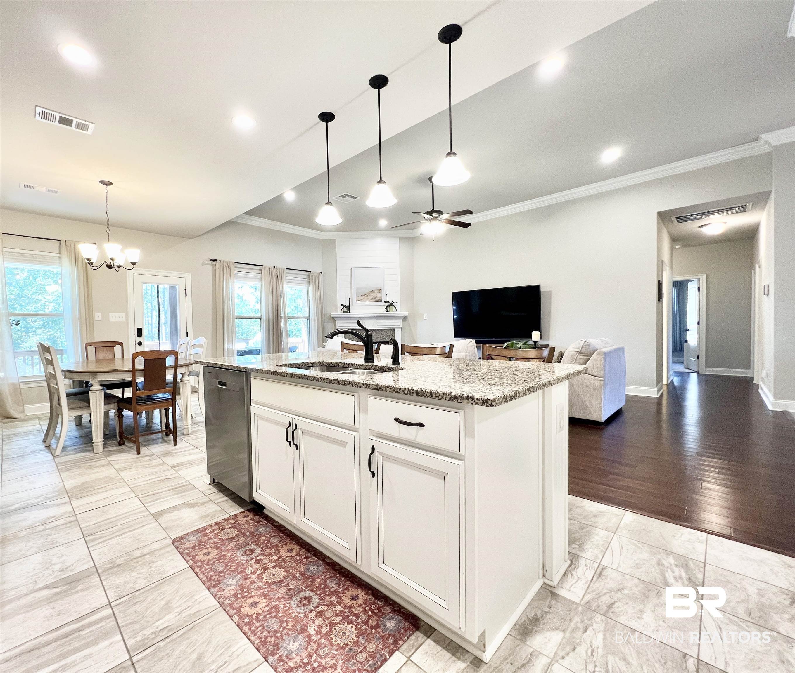 32290 Calder Court Daphne, AL 36527 - Photo 24 of 59 Kitchen with sink, white cabinetry, stainless steel dishwasher, light hardwood / wood-style flooring, and a kitchen island with sink