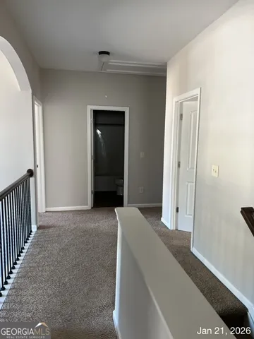 a view of hallway with closet and wooden floor