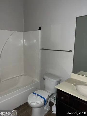 a white toilet sitting next to a bath tub