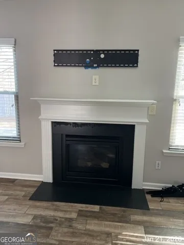 a living room with a fireplace and wooden floor