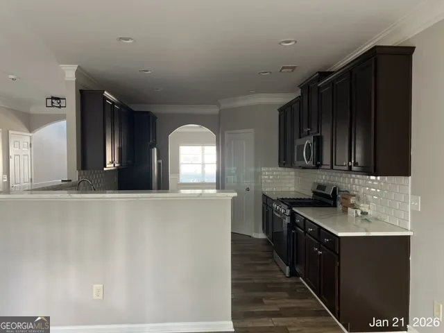 a kitchen with stainless steel appliances a sink stove and cabinets
