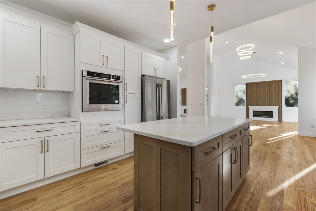 85 Jewell Street Mansfield, MA 02048 - Photo 14 of 42 a kitchen with stainless steel appliances kitchen island granite countertop a stove a sink and a refrigerator