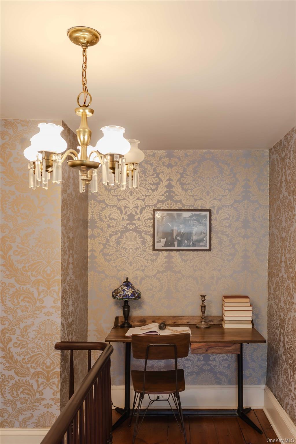 210 Middle Road Hudson, NY 12534 - Photo 30 of 42 Upper landing featuring patterned wallpaper, wood-finish flooring, and a brass-tone chandelier with crystal accents