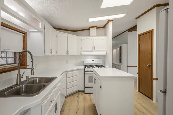 a kitchen that has a sink cabinets counter space and appliances