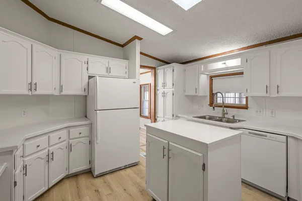 a kitchen with white cabinets and white appliances