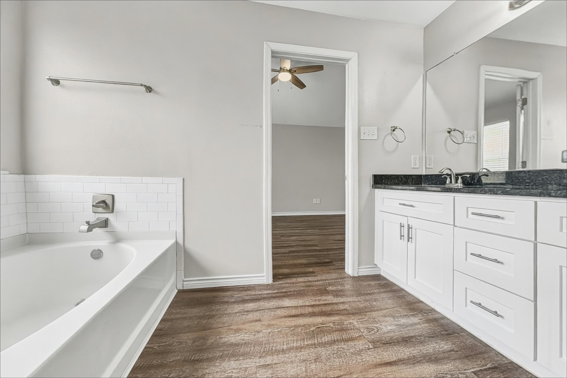 2423 Lofty Falls Court Spring, TX 77386 - Photo 11 of 15 a bathroom with a granite countertop sink a mirror and a bathtub