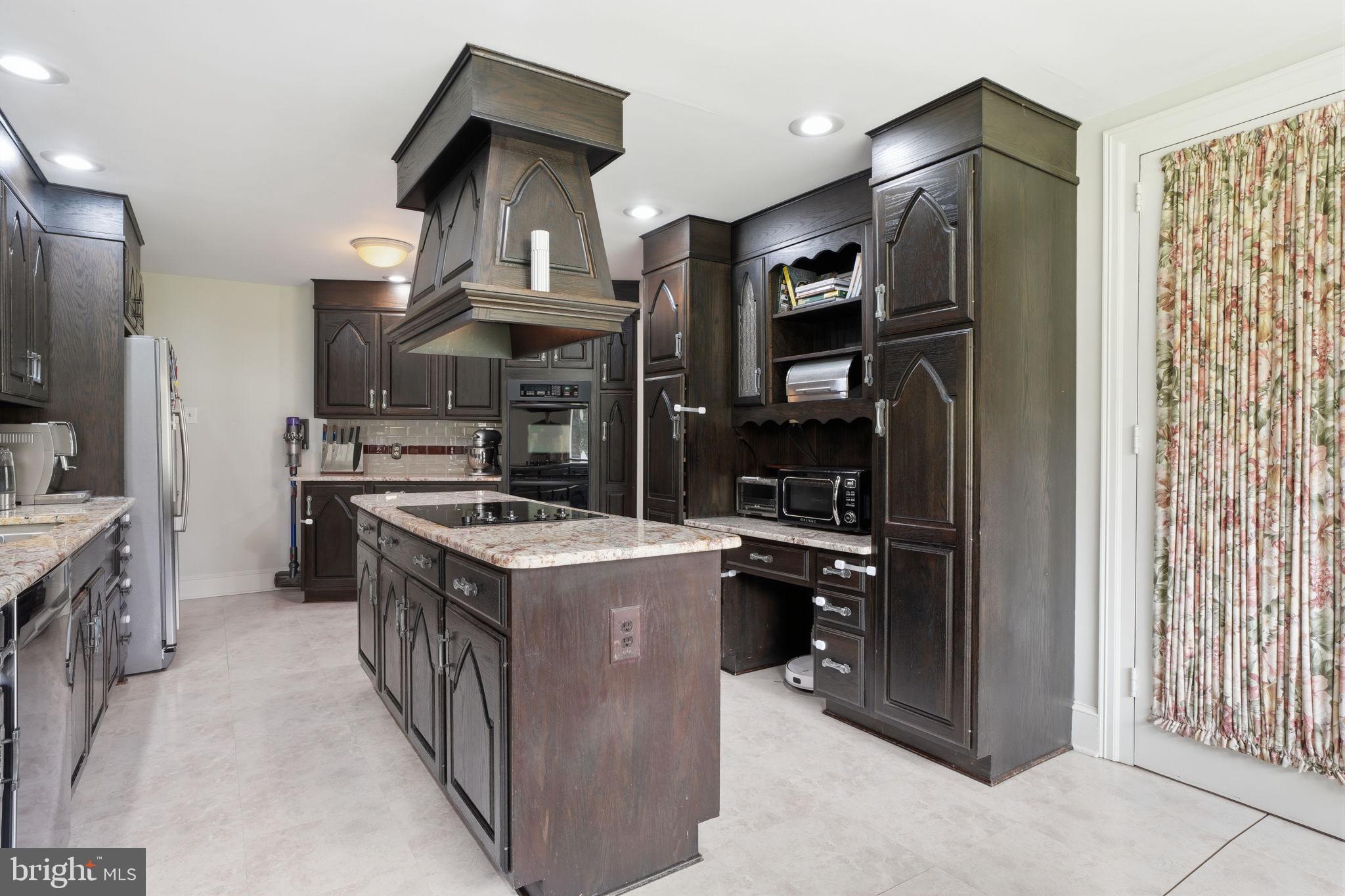 448 Moredon Road Huntingdon Valley, PA 19006 - Photo 13 of 66 a kitchen with stainless steel appliances granite countertop a stove top oven a refrigerator and a stove with wooden floor