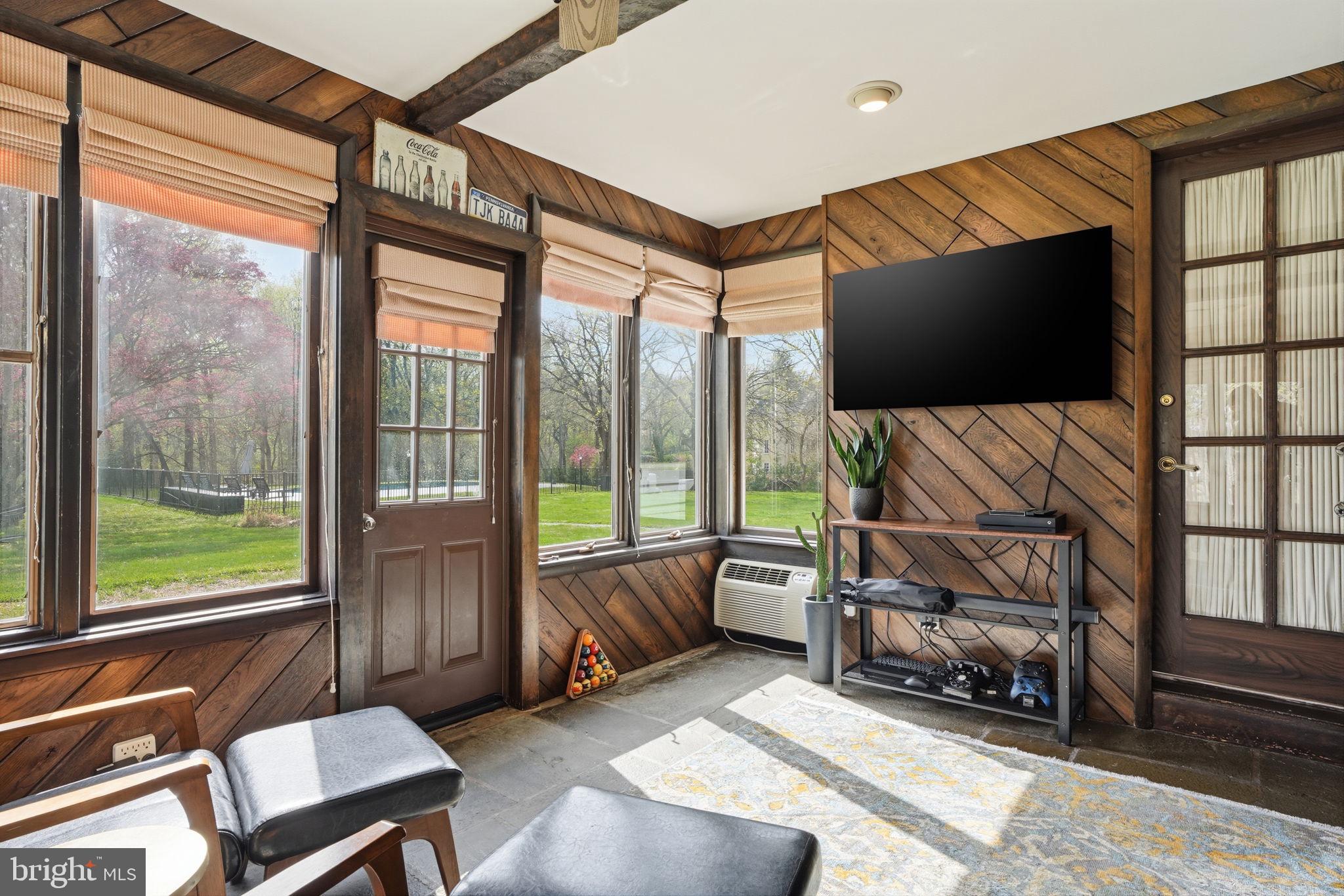 448 Moredon Road Huntingdon Valley, PA 19006 - Photo 37 of 66 a living room with furniture a flat screen tv and a floor to ceiling window