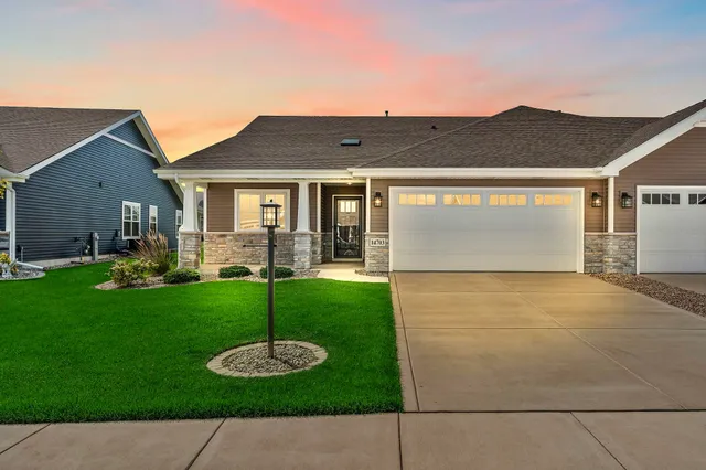 a front view of a house with a garden and yard
