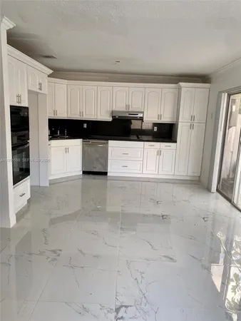 a view of kitchen with white cabinets