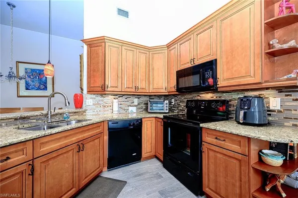a kitchen with stainless steel appliances granite countertop a stove sink microwave and cabinets