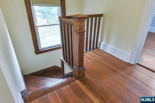 a view of a hallway with wooden floor and staircase