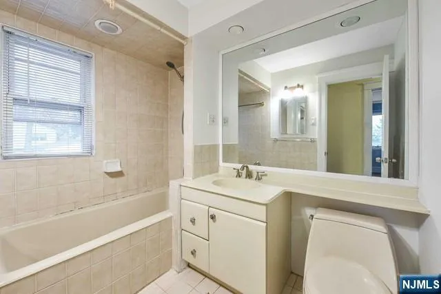 a bathroom with a granite countertop sink a toilet a mirror a vanity and shower