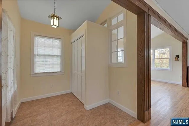 en empty room with windows and wooden floor
